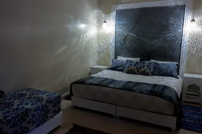 a bedroom with a bed with a mirror on the wall at Riad El Walida in Marrakech
