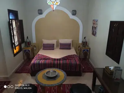 a bedroom with a bed and a table at Riad El Walida in Marrakech
