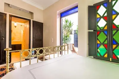 a bedroom with a bed with a stained glass window at Riad Boustane & SPA in Marrakech