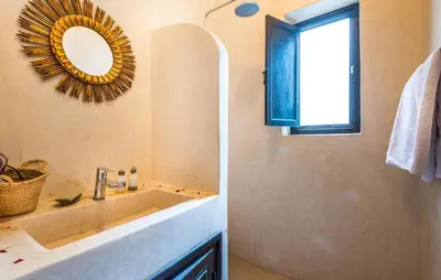 a bathroom with a sink and a mirror and a window at Riad Boustane & SPA in Marrakech
