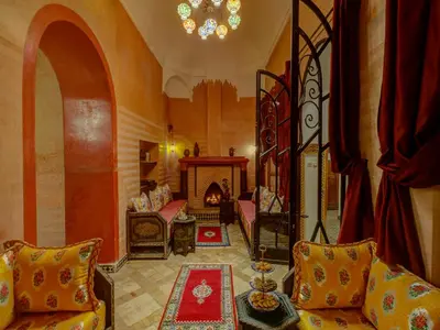 a living room with a couch and a fireplace at Palais Tinmel Marrakech in Marrakech