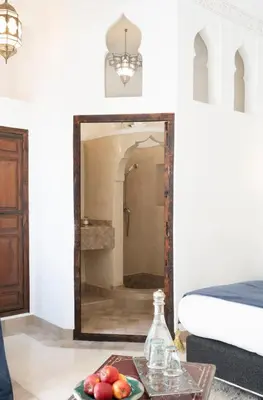 a mirror in a room with a bowl of fruit on a table at Riad Sashema in Marrakech
