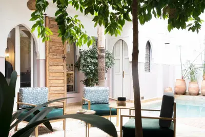 a room with chairs and a table and a pool at Riad Sashema in Marrakech