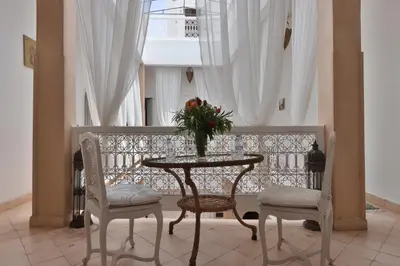 a table and chairs with a vase of flowers on it at Riad Morocco Sky in Marrakech