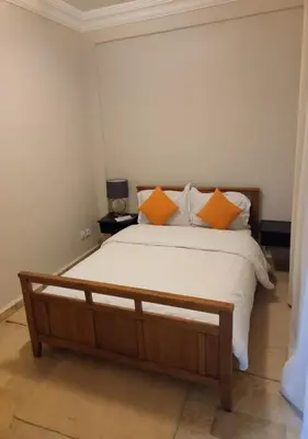 a bedroom with a large bed with orange pillows at Dar Guéliz in Marrakech
