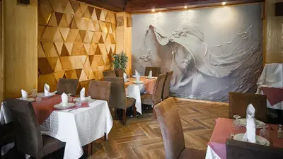 a dining room with tables and chairs and a painting at Hôtel Les Ambassadeurs in Marrakech