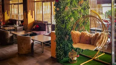 a room with a hanging chair in a restaurant at Hôtel Les Ambassadeurs in Marrakech