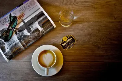 a table with a cup of coffee and a newspaper at 2Ciels Boutique Hôtel in Marrakech