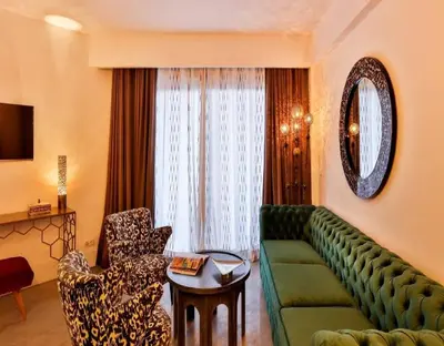 a living room with a green couch and a chair at 2Ciels Boutique Hôtel in Marrakech