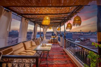 a balcony with a couch and a table on a balcony at Riad Sun of Kech in Marrakech