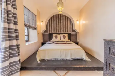 a bedroom with a bed and a large window at Riad Dar El Masa in Marrakech