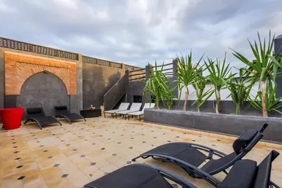 a patio with chairs and tables on a roof at Riad Dar El Masa in Marrakech