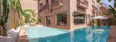 a swimming pool in front of a building at Dar Al Walidine in Marrakech
