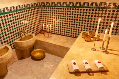 a bathroom with a sink and a tub and candles at Dar Al Walidine in Marrakech