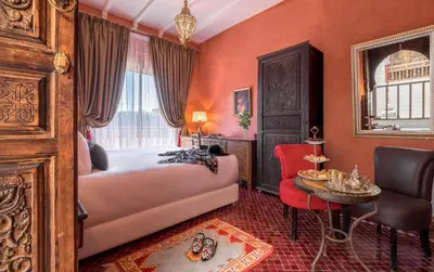 a bedroom with a bed and a table and a chair at Dar Al Walidine in Marrakech