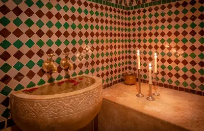 a bathroom with a tub with candles in it at Dar Al Walidine in Marrakech