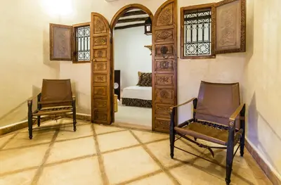 a room with two chairs and a door with a bed at Riad See Moon And Spa in Marrakech