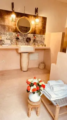 a bathroom with a vase of flowers on a stool at Riad See Moon And Spa in Marrakech