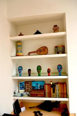 a shelf filled with lots of vases and books at Riad See Moon And Spa in Marrakech