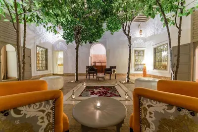 a living room with a table and trees in it at Riad See Moon And Spa in Marrakech