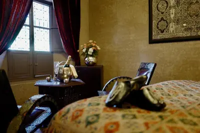 a bedroom with a bed with a shoe on the table at Riad Noir d'Ivoire in Marrakech