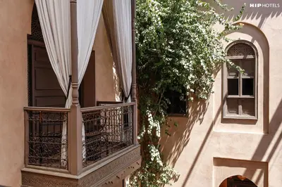 a balcony of a building with a window and a plant at Riad Noir d'Ivoire in Marrakech