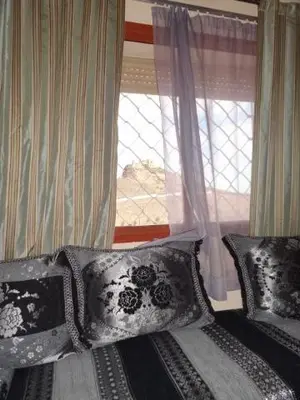 a bed with black and white pillows and a window at Apartment Twins 12 in Marrakech