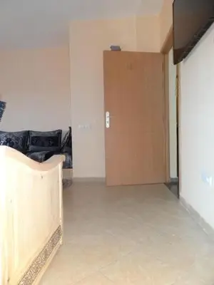 a room with a wooden door and a room with a couch at Apartment Twins 12 in Marrakech