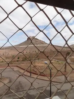 a view of a mountain through a chain link window at Apartment Twins 12 in Marrakech