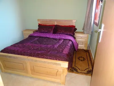 a bedroom with a bed with a purple comforter at Apartment Twins 12 in Marrakech