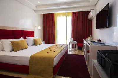 a hotel room with a large bed with a red headboard at Hôtel Racine in Marrakech