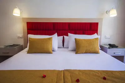 a bedroom with a large bed with a red headboard at Hôtel Racine in Marrakech