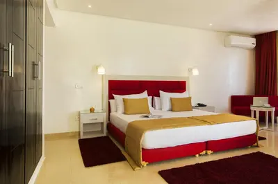 a bedroom with a large bed with a red headboard at Hôtel Racine in Marrakech