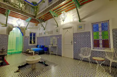 a room with blue and white tiles and a room with a sink at Riad Hôtel Essaouira in Marrakech