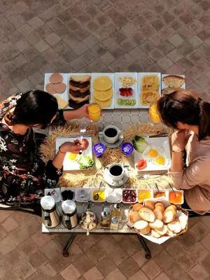 two women sitting at a table with food at Riad Bijoux Marrakech in Marrakech