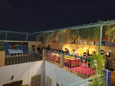 a group of people sitting on a balcony at night at The Madrassa Hostel in Marrakech
