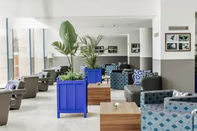 a waiting room with blue chairs and plants at Wazo Hotel in Marrakech