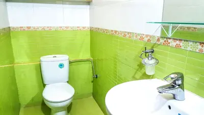 a green bathroom with a toilet and a sink at Villa Annakhil in Marrakech