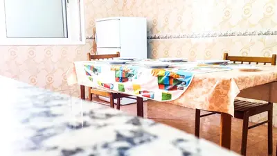 a kitchen with a table with chairs and a refrigerator at Villa Annakhil in Marrakech