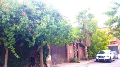 a white car parked next to a house with trees at Villa Annakhil in Marrakech