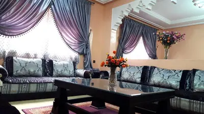 a living room with a couch and a table with flowers at Villa Annakhil in Marrakech