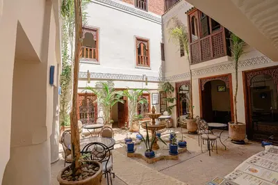 a courtyard with chairs and tables in a building at Riad Chams Marrakech in Marrakech