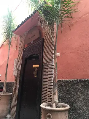 a front door of a building with two palm trees in pots at Riad Chams Marrakech in Marrakech