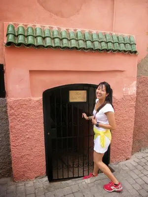 a woman standing in front of a black door at Riad Lapis-lazuli in Marrakech