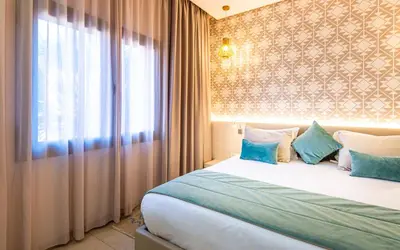 a bedroom with a bed with blue pillows and a window at TUI BLUE Medina Gardens - Adults Only - All Inclusive in Marrakech