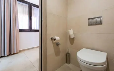a bathroom with a toilet and a window at TUI BLUE Medina Gardens - Adults Only - All Inclusive in Marrakech