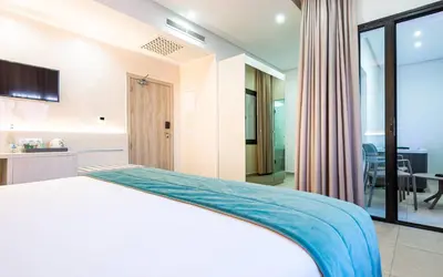 a bedroom with a white bed and a kitchen at TUI BLUE Medina Gardens - Adults Only - All Inclusive in Marrakech