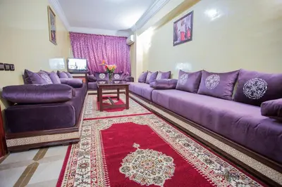 a living room with purple couches and a red rug at Appart Hotel Les Ambassadeurs in Marrakech