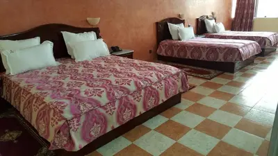 a hotel room with two beds and a checkered floor at Appart Hotel Les Ambassadeurs in Marrakech