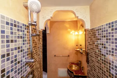 a bathroom with blue tiled walls and a shower at Riad Haj Thami in Marrakech